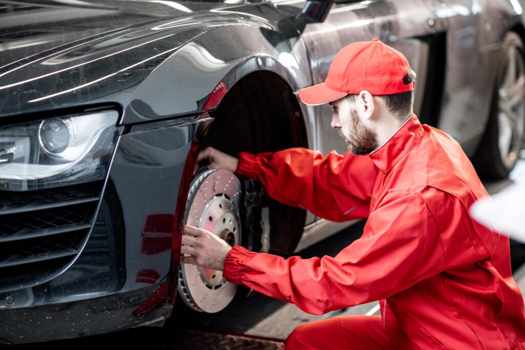 mechanic checking brakes in the car service